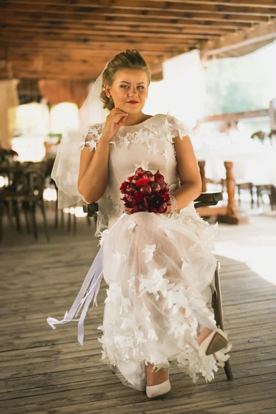 Tonificado tiro de hermosa novia sentado en la silla en el restaurante —  Fotos de Stock