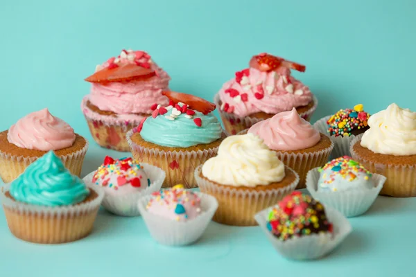 Primer plano de sabrosos cupcakes recién horneados y coloridos caramelos ove — Foto de Stock