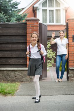 Gülümseyen kız evin arka bahçesinde dışında okula gidiyor