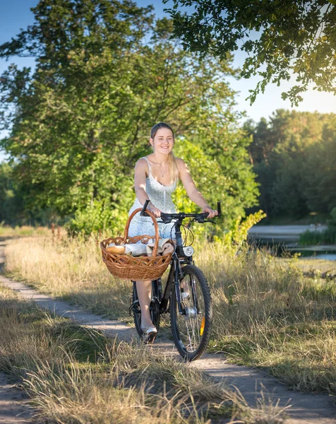 Lachende vrouw fietsten door de rivier op zonnige dag — Stockfoto