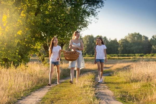 Bela mãe caminhando para piquenique com sua duas filhas — Fotografia de Stock