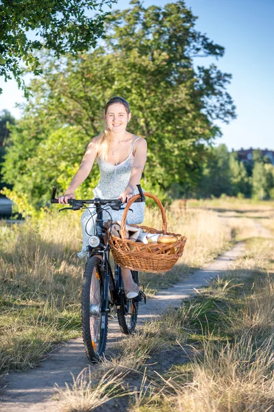 Mujer alegre bicicleta con cesta para picnic — Foto de Stock