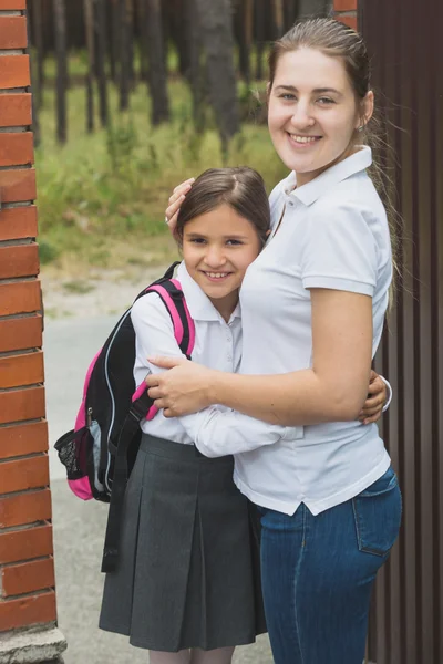 Anne ve kızı okul üniformalı sarılma güzel — Stok fotoğraf