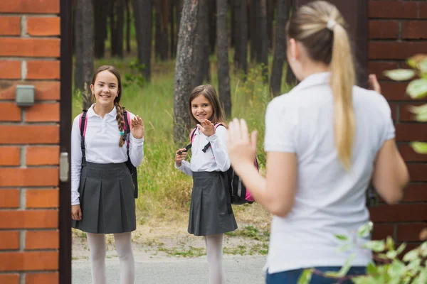 Moeder zien van haar twee dochters uit naar school — Stockfoto