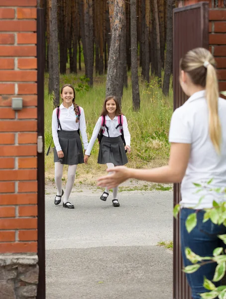 Matka, spotkanie jej córka po szkole, na podwórku domu — Zdjęcie stockowe