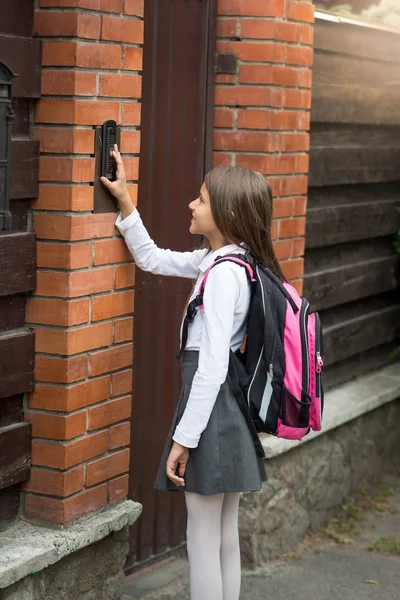 Όμορφο κορίτσι σε σχολική στολή πατώντας το κουμπί ενδοεπικοινωνίας — Φωτογραφία Αρχείου
