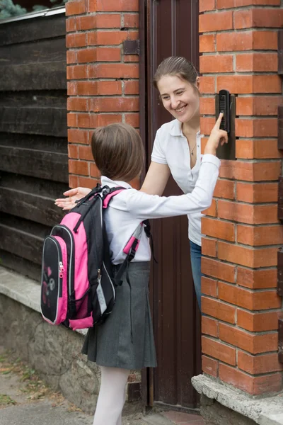 Matka otwierania drzwi do jej córki, który przyszedł ze szkoły — Zdjęcie stockowe