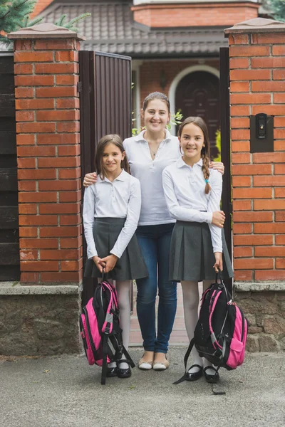 Jonge moeder in de deuropening staan met twee dochters verlaten voor — Stockfoto