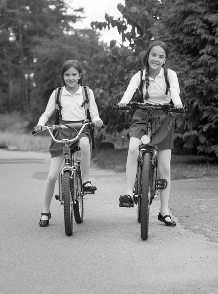 Kızlar okula bisiklet sürme gülümseyen bir siyah beyaz görüntü — Stok fotoğraf
