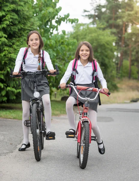 Счастливые девушки в форме едут в школу по утрам — стоковое фото