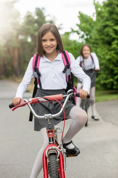 학교 유니폼 승마 자전거에 웃는 여자의 초상화 — 스톡 사진
