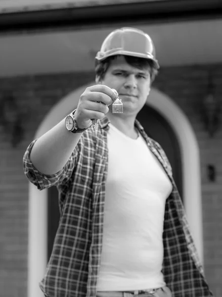 Black and white image of building site manager giving keys from — Stock Photo, Image
