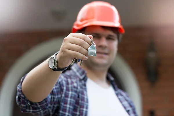 Zbliżenie, robotnika budowlanego trzyma klucze od nowego domu w ha — Zdjęcie stockowe