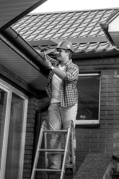 Zwart-wit foto van mannelijke werknemer dak herstellen — Stockfoto