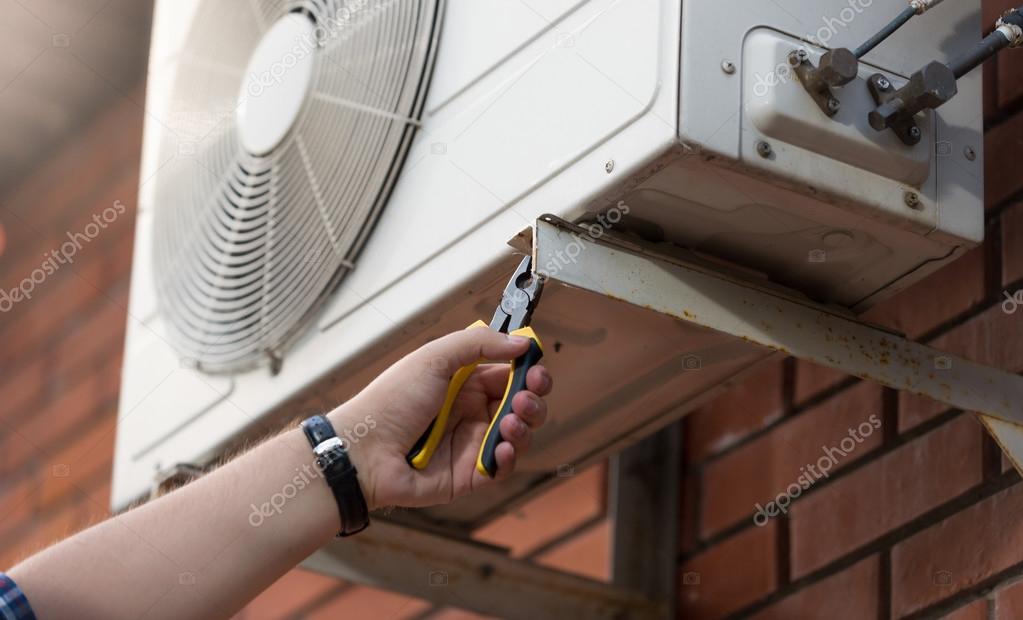 Closeup photo of technician installing outdoor air conditioning 