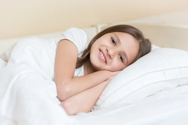 Retrato de chicas sonrientes tumbadas en la almohada y mirando a la cámara —  Fotos de Stock