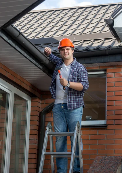 Arbeiter steht auf Leiter vor Haus — Stockfoto