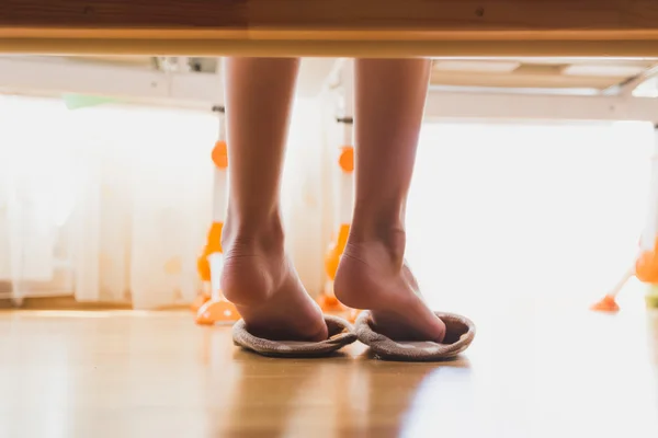 Tonificado foto de cerca de la niña que se pone zapatillas después de despertar —  Fotos de Stock