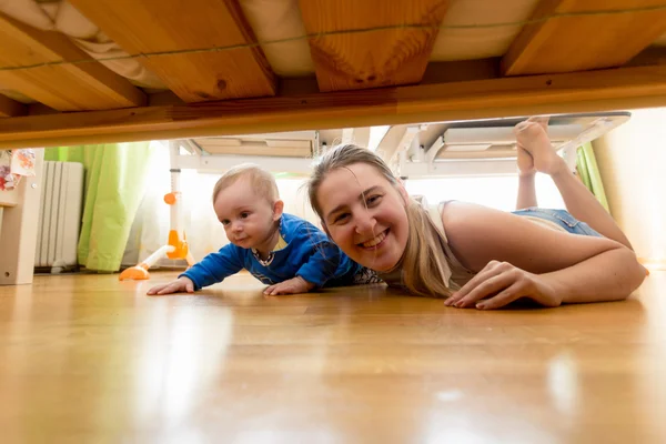 Šťastný matka a chlapeček ležel na podlaze a při pohledu pod b — Stock fotografie