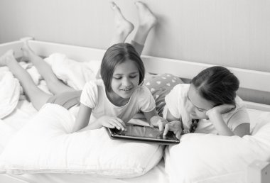 Siyah beyaz portre iki kız yatakta m tablet kullanma