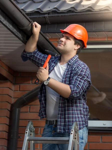 Portret van timmerman in veiligheidshelm onderzoeken huis dak — Stockfoto