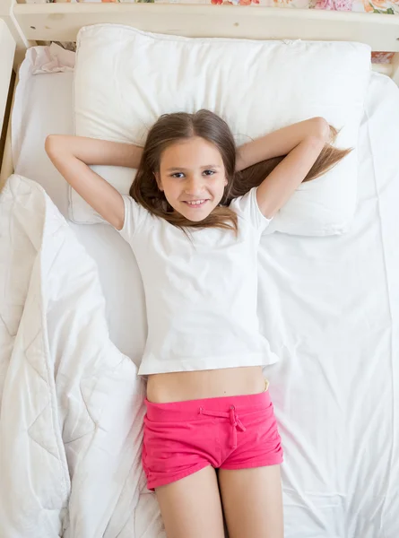 View from above on cute girl lying on bed and looking at camera — Stock Photo, Image