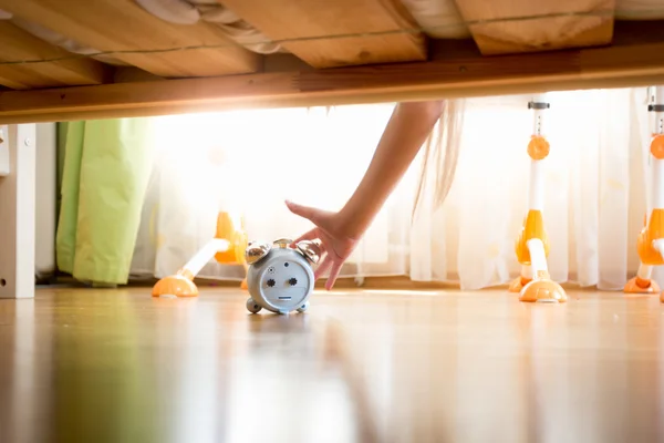 Nahaufnahme einer jungen Frau, die unter das Bett greift und dösen drückt — Stockfoto