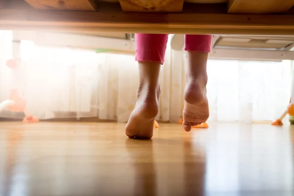 Image from under the bed on girl stepping on wooden floor at bed — Stock Photo, Image