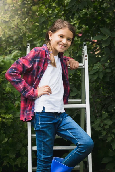 10 year old girl posing at stepladder in garden — Stock Photo, Image
