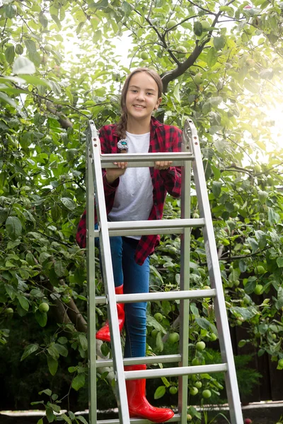 Imagen tonificada de una adolescente feliz posando en una escalera en Apple — Foto de Stock