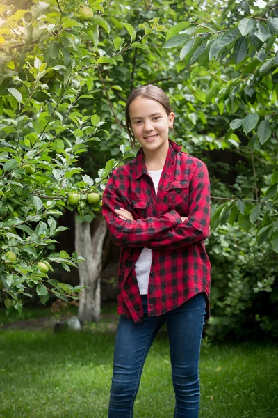 Teenager-Mädchen im rot karierten Hemd posiert im Apfelgarten — Stockfoto