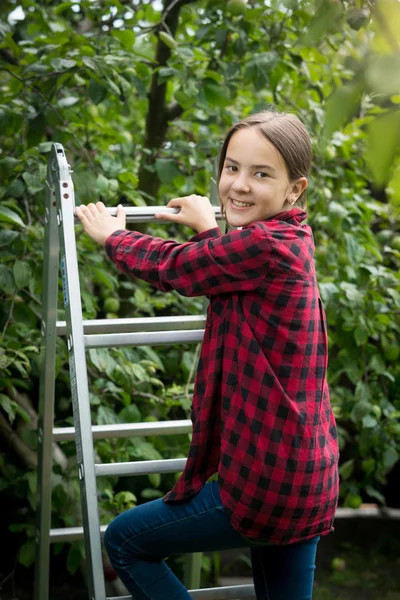 Portrait of smiling teenage girl in red checkered shirt climbing — Stock Photo, Image