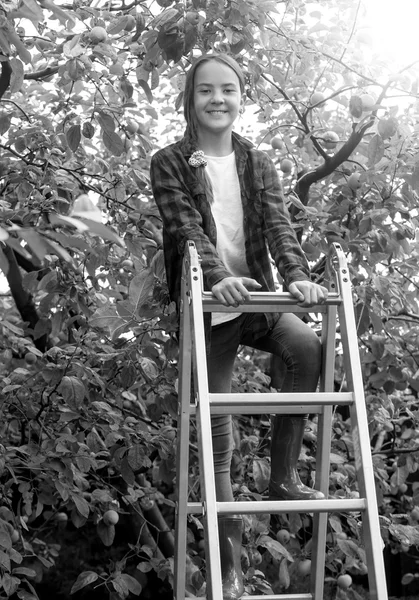 Черно-белое изображение счастливой улыбающейся девушки, поднимающейся по ступенькам — стоковое фото