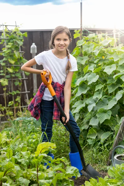 Симпатичная 10-летняя девочка работает в саду и копает почву — стоковое фото
