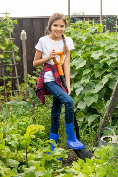 Glückliches Mädchen, das mit Schaufel im Garten arbeitet — Stockfoto