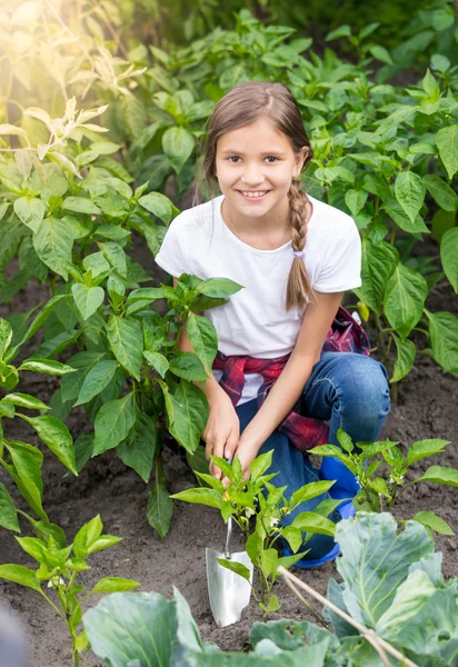 Tonårig flicka arbetar på garden med hand spade — Stockfoto