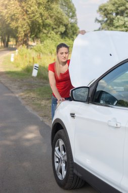 Genç kadın yol kenarında duran ve başlık altında seyir 