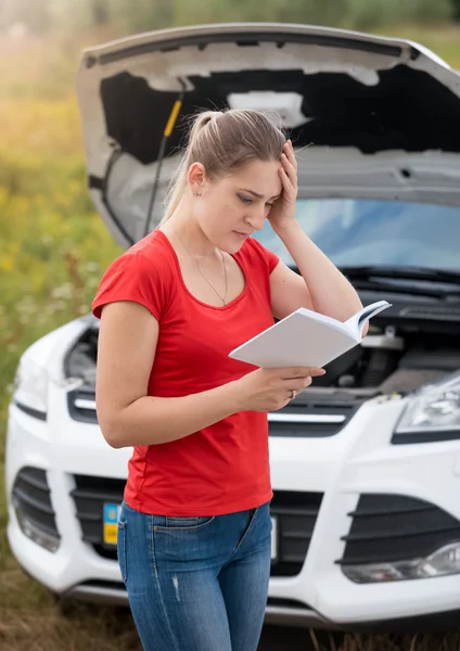 Portrait of woman in despair reading owner manual to the broken — Stock Photo, Image