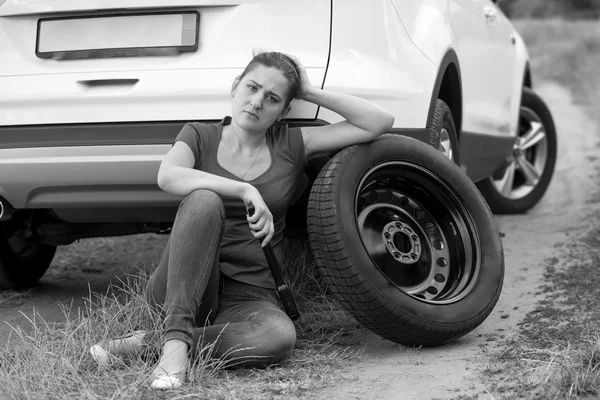 Imagen en blanco y negro de la mujer triste sentada en el suelo en ca roto —  Fotos de Stock