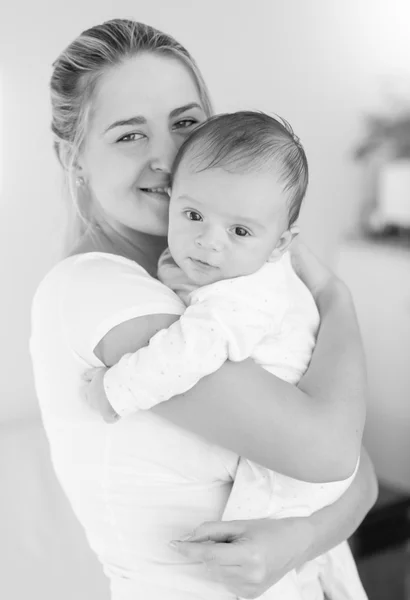 Черно-белый образ веселой матери, обнимающей своего малыша — стоковое фото
