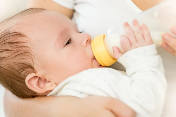 Portrait of cute 3 months old baby boy drinking milk from bottle Stock Picture