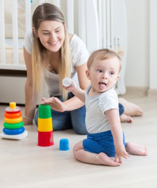 Gülümseyen anne onun erkek bebek oyuncak piramit montaj