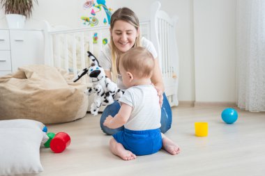 Neşeli anne yapma kukla gösterisi ile onun güzel bebek çocuk