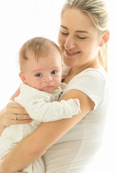 Getöntes Porträt einer lächelnden fürsorglichen Mutter, die ihre 3 Monate alte Tochter knuddelt — Stockfoto