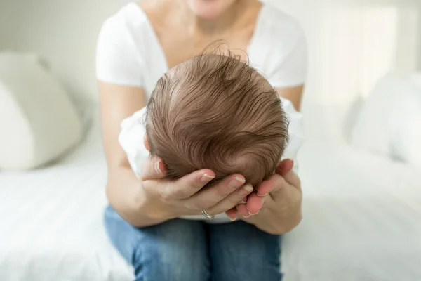 Nahaufnahme der Hände der Mutter, die den Kopf des schlafenden 3 Monate alten Kindes hält — Stockfoto