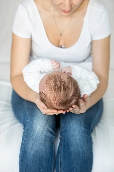 Primo piano della giovane madre premurosa che tiene la testa del suo piccolo bambino — Foto Stock