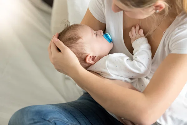 Getöntes Bild eines Jungen, der auf den Händen der Mutter schläft — Stockfoto