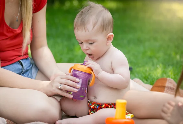 Portret chłopca, picie soku z butelki na piknik w — Zdjęcie stockowe