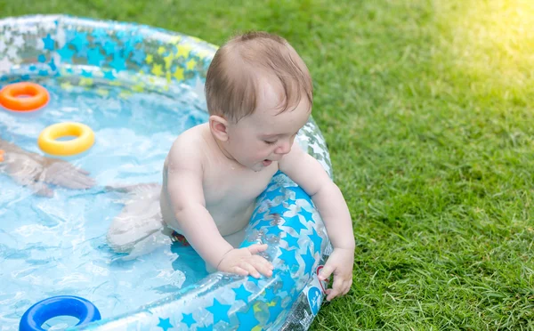 Bambino che gioca in piscina in giardino — Foto Stock