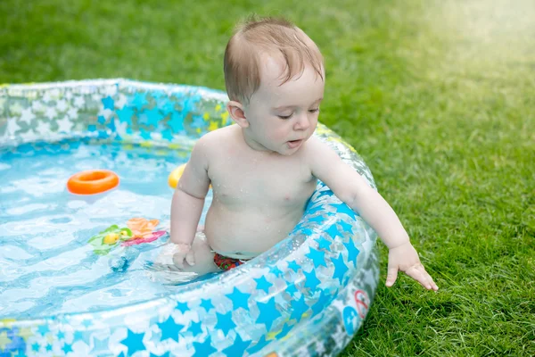Bambino felice nella piscina gonfiabile in cortile — Foto Stock
